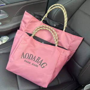 Pink large capacity nylon tote bag with patterned handles, perfect for daily commuting and shopping.