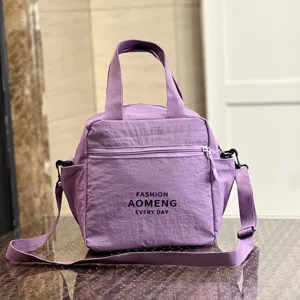 Purple insulated lunch bag detail with waterproof fabric, handles and front zipper pocket.