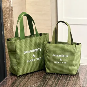 Detailed view of green grid tote bags, showing large capacity, double handles and clean stitching.