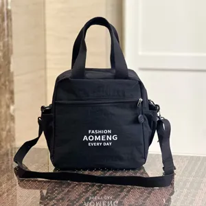 Waterproof black lunch bag with shoulder strap, ideal for commuting and daily use.