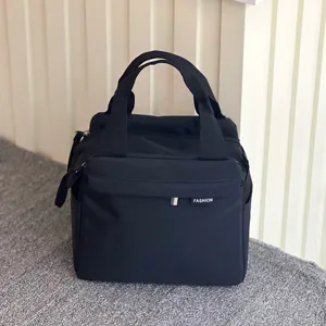 Waterproof lunch bag detail view showing sturdy fabric handles and front pocket for daily use.