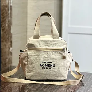 Detail view of the beige waterproof insulated lunch bag, showing fabric texture and zippers.