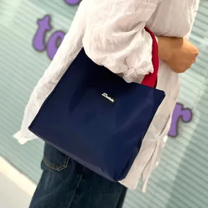 Spacious color block lunch handbag with red handles for daily work and casual out.