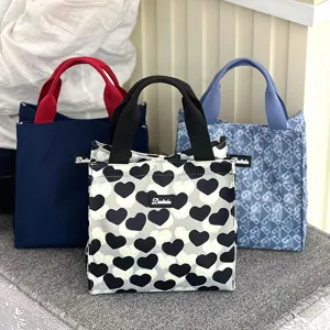 Detailed view of fashionable canvas lunch bags featuring stylish heart and patterns.