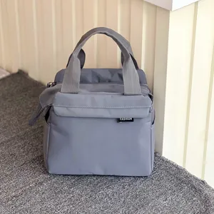 Detail view of the grey waterproof insulated lunch bag, showing durable fabric and front pocket.