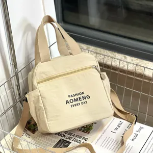 Detail shot of the beige canvas lunch bag featuring zipper closure, side pockets, and strap.