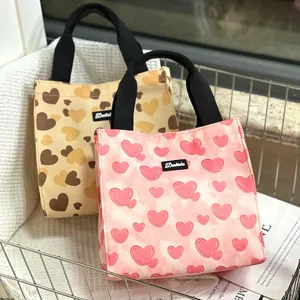Canvas lunch tote bag with cute heart pattern, durable black handles for daily work or school.