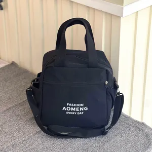 Black insulated lunch bag with bottle pocket, waterproof crossbody and handbag design.
