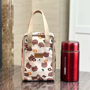 Detail shot of the cute cartoon bear insulated lunch bag with durable canvas handles and pocket.
