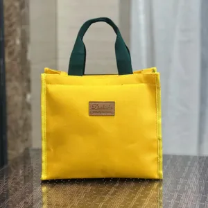 Borsa porta pranzo in tela gialla con manici verde scuro, semplice borsa bento per studenti.