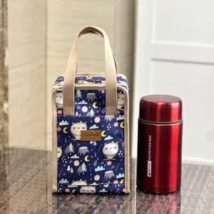 Detailed view of the insulated lunch bag with owl print, featuring dual handles and side pocket.
