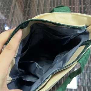 Canvas lunch bag interior detail showing multiple handy compartments and secure zipper top.