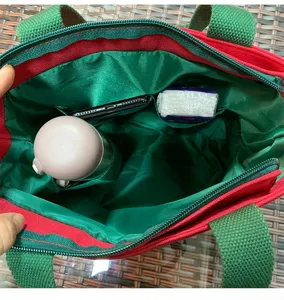 Canvas lunch tote bag interior view with built-in cup holder and side pockets for storage.