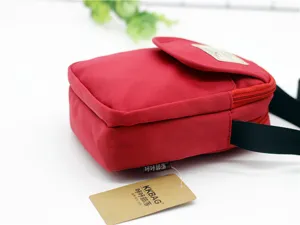 Detalle de bolso bandolera de nailon rojo que muestra tela resistente y correa.