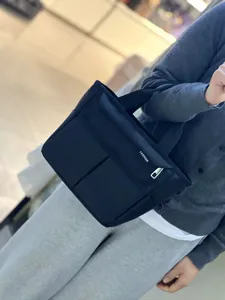 Details of black multi-pocket canvas lunch bag with zipper and handles for daily use.