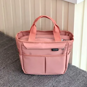 Detailed view of the pink multi-pocket insulated lunch bag with front pocket and durable handles.