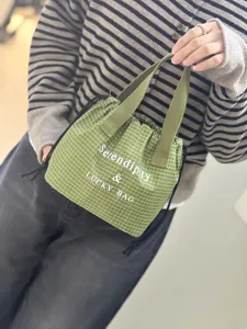 Sac à déjeuner étanche à carreaux verts avec cordon et poignées pour le travail quotidien.