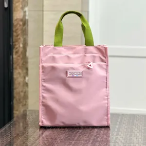 Pink tote lunch bag detail closeup with green handles and front zipper pocket for daily use.