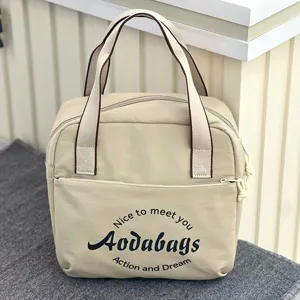 Détail de sac de voyage en tissu oxford beige, grand cabas avec poignées et poche avant.