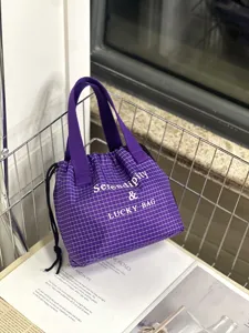 Vue détaillée à carreaux pourpre d'un sac bento imperméable avec texte blanc mignon.