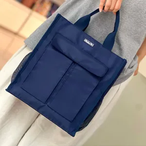 Detailed view of the dark blue multi-pocket canvas document bag with side mesh pockets.