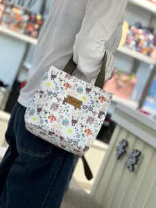 Small waterproof cartoon lunch bag for students and commuters, portable bento tote with cute prints.