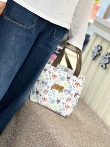 Detailed view of waterproof cartoon student lunch bag with sturdy handles and insulated interior design.