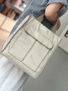 Detail view of the multi-pocket canvas tote bag showing spacious compartments and sturdy straps.