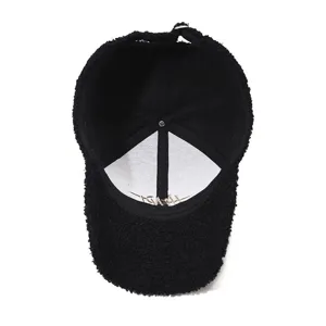 Close-up view of the interior lining and stitching of a black teddy fleece baseball cap.