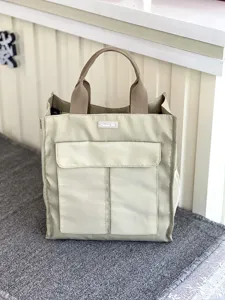 Detailed view of large capacity multi-pocket canvas handbag student document bag beige.