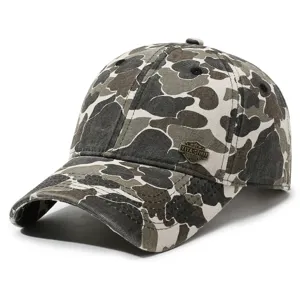 Washed camo baseball cap detail view showing the distressed fabric and metal badge design.