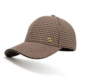 Detailed shot of brown houndstooth baseball cap featuring a sparkling gold rhinestone emblem.