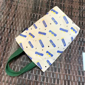 Canvas thermos cup bag detail shot with green handles and cute patterned design for daily use