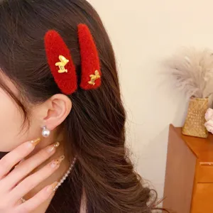 Red plush hair clips with cute golden horse charm, stylish winter hair accessories for women.