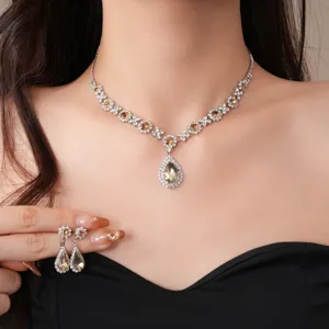 Exquisito juego de collar y pendientes de lágrima de cristal con elegantes detalles de pedrería.