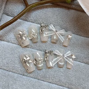 10 uñas postizas hechas a mano con efecto ojo de gato, lazos dulces y pedrería de nieve.