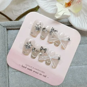 Uñas postizas hechas a mano con lazos bonitos y pedrería brillante, diseño corto y elegante.