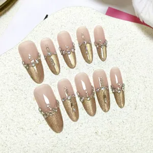 Set de uñas postizas de lujo con puntas doradas ojo de gato y perlas de diamantes.