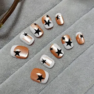 Handgemaakte neppe nagels met koperen cat-eye effect, witte Franse tips en zwarte sterrenmotieven.