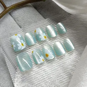 Handmade short press-on nails with blue cat eye gel and cute white daisy floral art, 10pcs set.