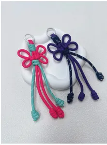 Close-up of handmade color-blocked woven knot keychain charm, detailed texture and stylish design.