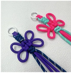 Handcrafted woven flower keychain detail shot, colorful double knot bag charm accessory.
