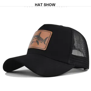 Detalle de cerca de la gorra de béisbol negra con parche de tiburón de cuero marrón.