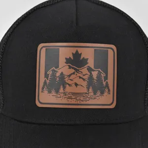 Gedetailleerd overzicht van zwarte trucker pet met Canadese esdoorn lederen patch