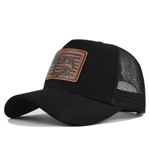 Close-up view of the black trucker hat with brown leather fish patch, mesh back and curved brim.