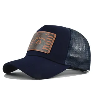 Detailed view of the blue mesh trucker hat showing the front brown leather raccoon patch.