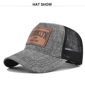 Grey mesh baseball cap with brown leather patch, stylish Brooklyn 1898 summer trucker hat.