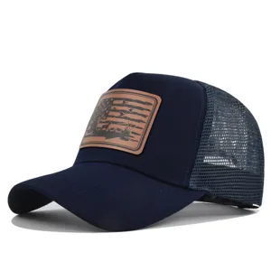 Detailed close-up of a dark blue mesh baseball cap with hunting leather patch design.