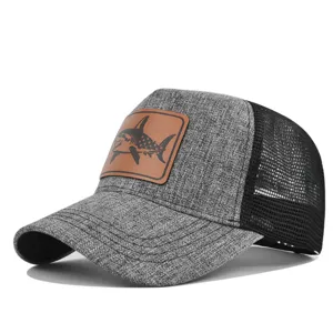 Vista detallada de la gorra de béisbol gris con parche de tiburón de cuero y malla.
