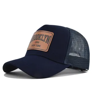 Navy blue trucker hat featuring a brown leather patch with Brooklyn 1898 New York text.